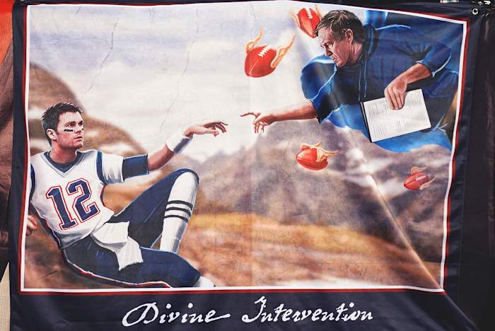 A banner depicting Tom Brady and Bill Belichick in Michelangelo’s painting, ‘Creation of Adam from the Sistine Chapel.’
